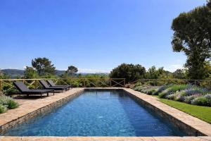 a swimming pool in a garden with two lounge chairs next to it at Villa Gianotti by MMega in Lugnano