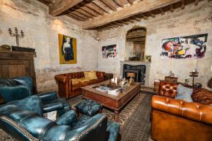 a living room with leather furniture and a fireplace at Villa Gianotti by MMega in Lugnano +35 photos