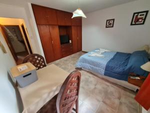a bedroom with a bed and a table and a table and chairs at Cabanas Las Pencas, HOSTERIA in Mina Clavero +20 photos