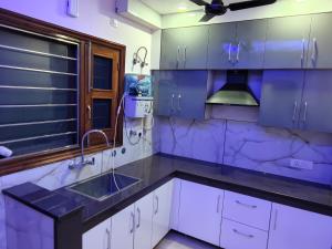 a kitchen with white cabinets and a sink at Homestay Mohali in Chandigarh Airport