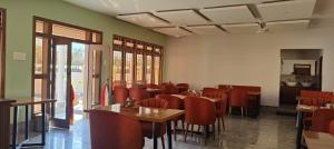 a dining room with tables and red chairs at Rivero Resort in Dirang Dzong