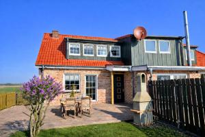 a house with a table and a fence at "Huus ant Diek", Ferienhaus mit Maisonette Wohnung in Deichnähe, Nähe Norddeich in Norden