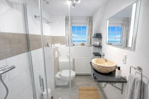 a bathroom with a sink and a toilet at "Huus ant Diek", Ferienhaus mit Maisonette Wohnung in Deichnähe, Nähe Norddeich in Norden +30 photos