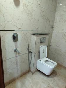 a bathroom with a toilet and a phone on the wall at Homestay Mohali in Chandigarh Airport