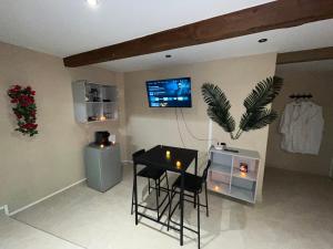 a living room with a table and a tv on the wall at Le Cocon SPA Évasion Privée - jacuzzi - in Lunel