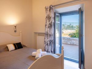 a bedroom with a bed and a sliding glass door at Paros Tranquility Villa in Dhragoulás