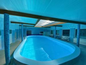 a large swimming pool in a building with a ceiling at Perła Świeradowa in Świeradów-Zdrój