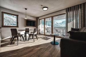 a living room with a couch and a table with chairs at Residence Froy in Resia