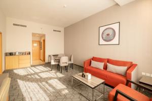 a living room with a red couch and a table at Peony Hotel in Dubai