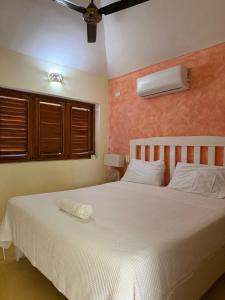 a bedroom with a white bed with a fan at Villa with Stunning Ocean View, Infinity pool in Las Terrenas +16 photos