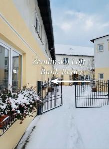 a snow covered walkway in front of a building at Zemlinsky Loft Bunk Room in Payerbach