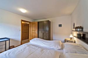 a bedroom with a large white bed in it at Chesa Chamuotsch - Celerina in Celerina