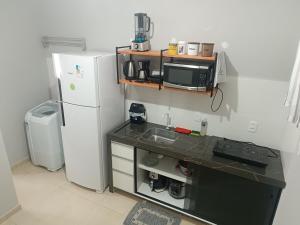 a small kitchen with a sink and a refrigerator at Loft mobiliado in Joinville +4 photos