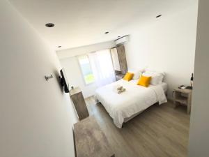 a bedroom with a white bed with yellow pillows at Mar y Cielo in Necochea