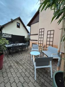a patio with tables and chairs and a building at Le BERG'KAY in Kaysersberg