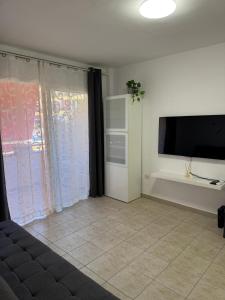 a living room with a flat screen tv on a wall at Casa de Rufio With Pool Tenerife in Puerto de Santiago