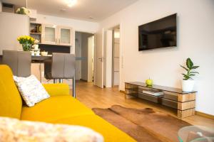 a living room with a yellow couch and a tv at Rosaliya in Cochem