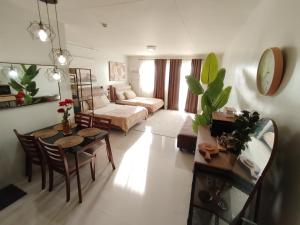 a living room with a table and a couch at Puerto Princesa Studio Condo with 2 Large Beds, Balcony, Pool & Gym in Puerto Princesa City +64 photos