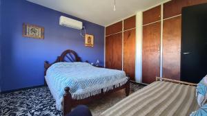 a bedroom with a bed and a blue wall at El Tesoro Cordobés in Córdoba