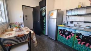 a kitchen with a table and a refrigerator at El Tesoro Cordobés in Córdoba +12 photos