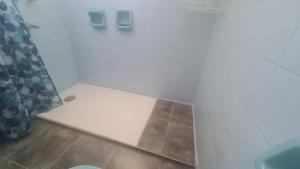 a bathroom with a shower curtain and a tile floor at El Tesoro Cordobés in Córdoba