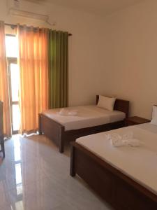 a room with two beds and a window at Aluthwewa Gate in Angunakolapelessa