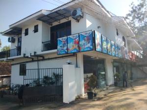 a white building with signs on the side of it at Aluthwewa Gate in Angunakolapelessa
