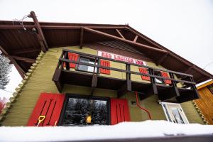 a house with red doors and a sign on it at Red Shutter Inn in Rossland