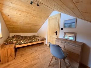 a bedroom with a bed and a chair in a room at Domek pod Głazami in Ostre