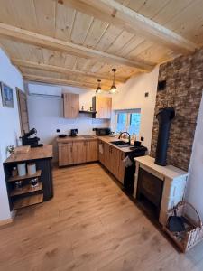 a large kitchen with wooden cabinets and a stove at Domek pod Głazami in Ostre