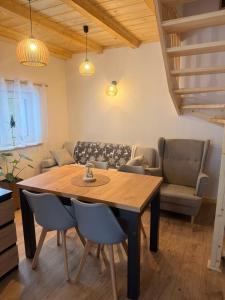 a living room with a wooden table and chairs at Domek pod Głazami in Ostre +16 photos