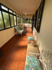 a hallway with beds and chairs in a room with windows at Elisabeth House in Ponta do Sol