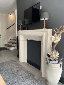 a living room with a fireplace with a tv above it at Ferienwohnung LA MAISON mit Sauna am See in Neuenkirchen