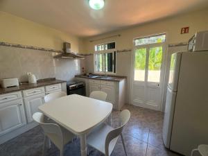 a kitchen with a white table and a white refrigerator at Elisabeth House in Ponta do Sol