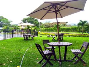 a table and chairs with an umbrella in the grass at Llano grande rivera in Rivera