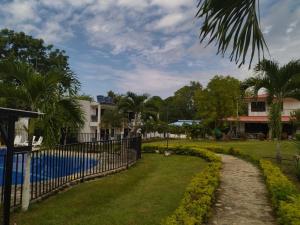 a house with a fence and a yard with a pool at Llano grande rivera in Rivera