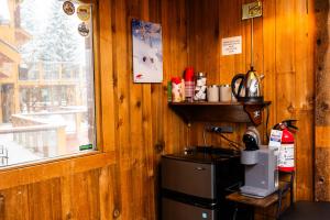 a kitchen with wooden walls and a window and a refrigerator at Red Shutter Inn in Rossland