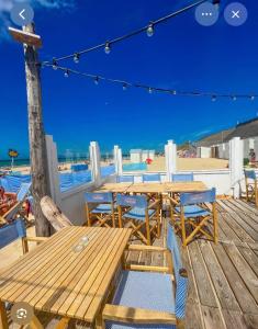 a wooden deck with tables and chairs on the beach at Le face mer in Le Portel