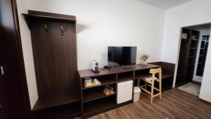 a room with a desk with a television and a cabinet at Szende Vendégház in Villány
