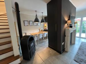 a kitchen with a stove and a dining room with a table at Ferienwohnung LA MAISON mit Sauna am See in Neuenkirchen