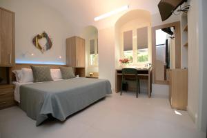 a bedroom with a bed and a desk and a kitchen at Dimora del Cuore GUEST HOUSE IN Centro in Vieste