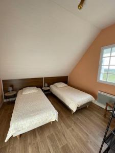 a room with two beds and a window at Le OUESSANTIN in Lampaul