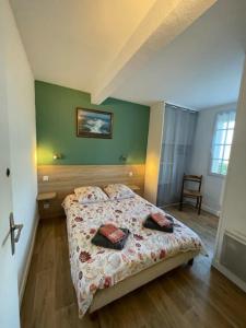 a bedroom with a bed and a green wall at Le OUESSANTIN in Lampaul