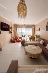 a living room with a couch and a table at 2BR Luxury Apartment-Heart Of Taghazout, Private Beach Access, Panoramic View, Remote Work 100Mbps, Walk to Restaurants in Taghazout