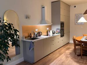 a kitchen with a sink and a table in a room at Appartement de charme en plein cœur du centre historique - Parking Public Gratuit - in Avallon