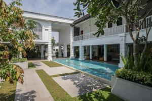 an exterior view of a house with a swimming pool at Hibiscus Beach Hotel & Villas in Kalutara