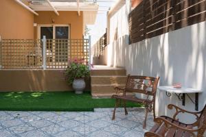 a porch with two chairs and a vase of flowers at Beach House Lefkes B in Zakynthos +9 photos