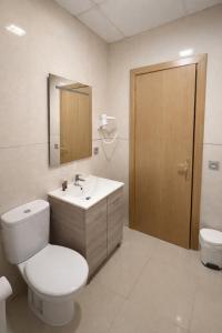 a bathroom with a toilet and a sink and a mirror at Hotel Molí Beach in Benidorm