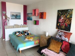 a bedroom with a bed and a chair in it at La bellevue in Les Trois-Îlets