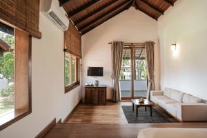 a living room with a couch and a tv at Hibiscus Beach Hotel & Villas in Kalutara